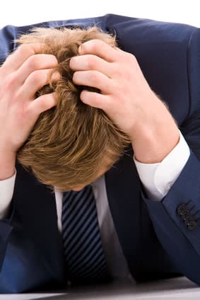 Portrait of tired businessman touching his head