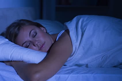 Serene woman sleeping at night in the bedroom