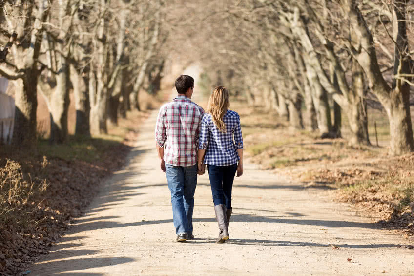 30591900 - rear view of couple holding hands walking in autumn countryside