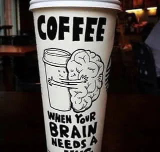 Disposable coffee cup with cartoon brain illustration and text reading 'Coffee when your brain needs a hug'