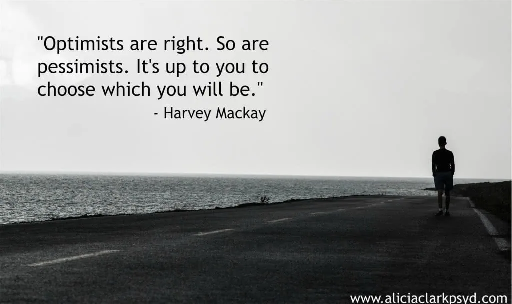 Silhouette of person standing on dark road facing calm ocean water with Harvey Mackay quote about optimism and pessimism