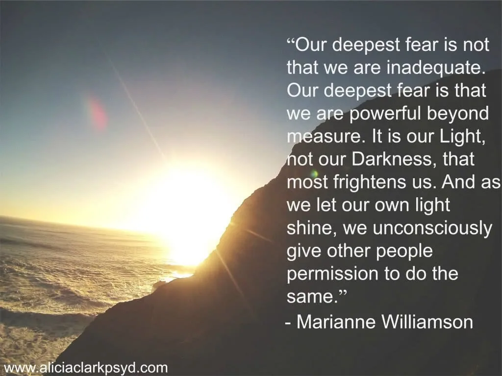 Silhouetted mountain peak with sun rising over ocean horizon and inspirational quote about light and power overlaid in white text