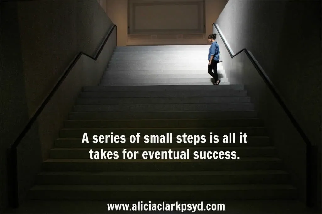Person climbing stairs toward light with motivational quote about small steps leading to success