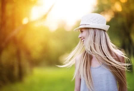 35800973 - attractive young woman enjoying her time outside in park with sunset in background.