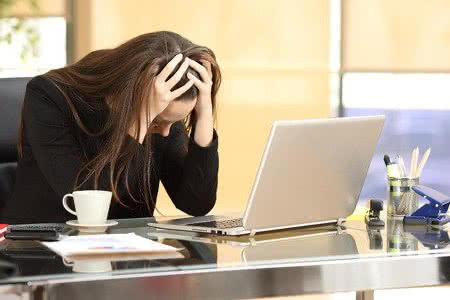 61935138 - desperate businesswoman on line worried after bankruptcy in front of a laptop with her hands in the head at office