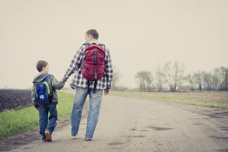 75820836 - father and son walking on the road at the day time. people having fun outdoors. concept of friendly family.