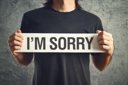 25374459 - man holding i am sorry message on white board. remorse concept.