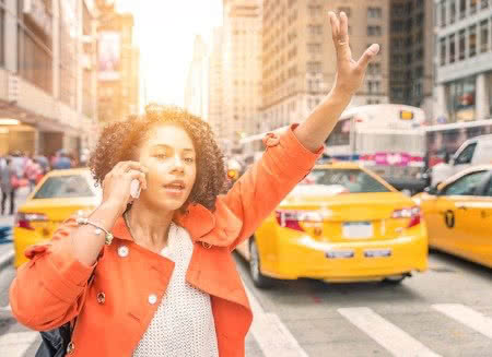 47116321 - afro american woman calling a taxi in new york near time square district. concept about urban life, people and transportation