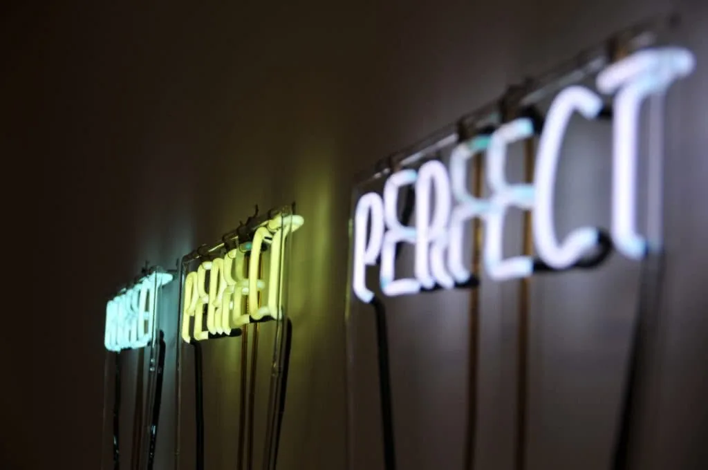 Neon signs glowing in blue, green, and white against a dark background
